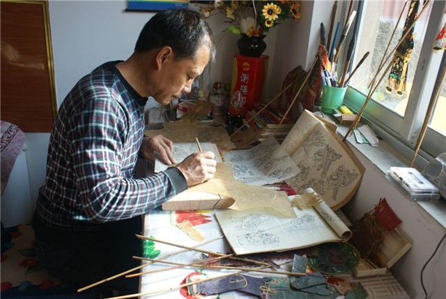 1552984567829179.jpg 通渭影子腔国家级代表性传承人刘满仓在制作影人.jpg